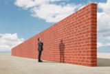 Mann schaut will über hohe Mauer schauen